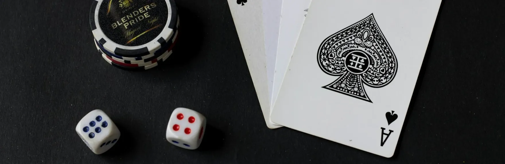 Mesa de casino de orobet sobre fondo oscuro con fichas, dados y cartas con as de picas, ambiente premium